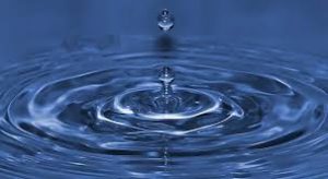 Una goccia cade nello specchio d'acqua, metafora della gioia